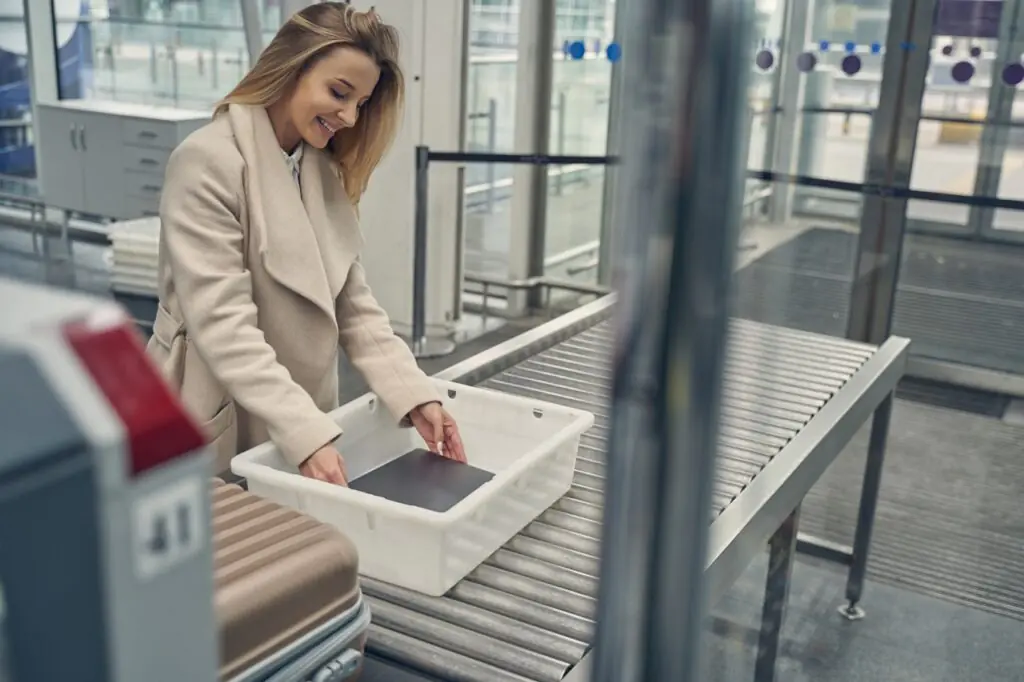 Travel Sentry | What Do You Have to Remove at Airport Security? Traveler going through an airport security checkpoint