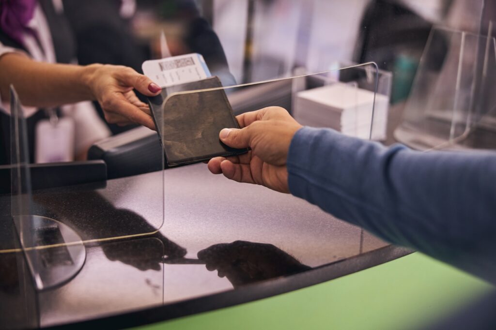Travel Sentry | What Happens If Immigration Stops You at the Airport Cropped photo of a Caucasian male tourist handing his travel documents to a female employee